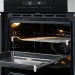 Interior iluminado do Forno Oven Grill Crissair, com a grade puxada e a bandeja abaixo